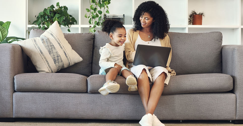 Mother and daughter looking at laptop on couch in living room