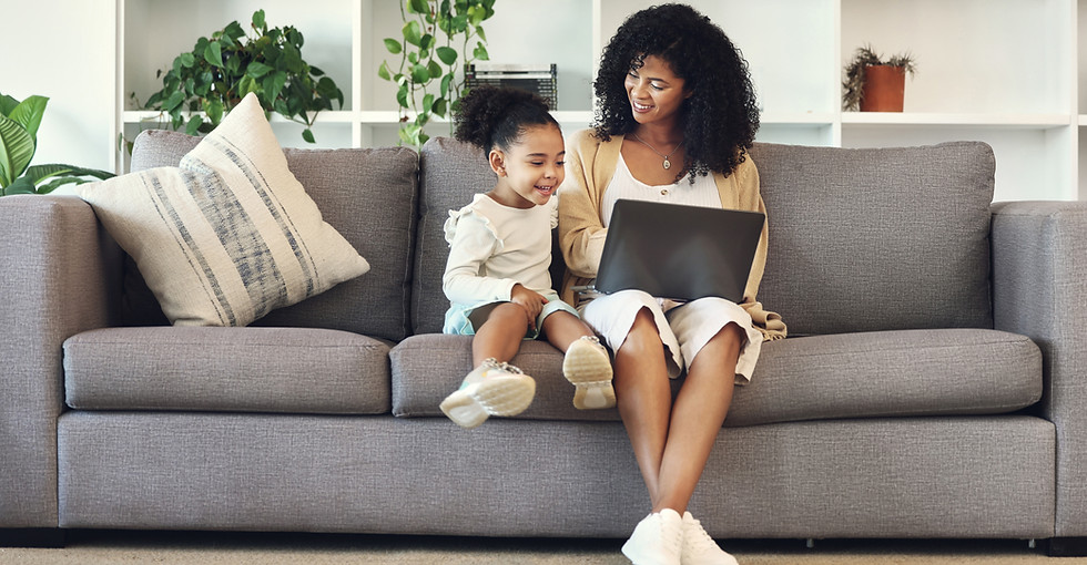 Mother and daughter looking at laptop on couch in living room